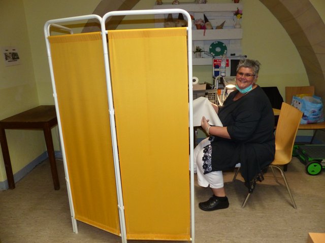 Paravents sorgen für Sichtschutz an den einzelnen Behandlungsstationen. Hier: Podologin Britta Streu bei der Arbeit