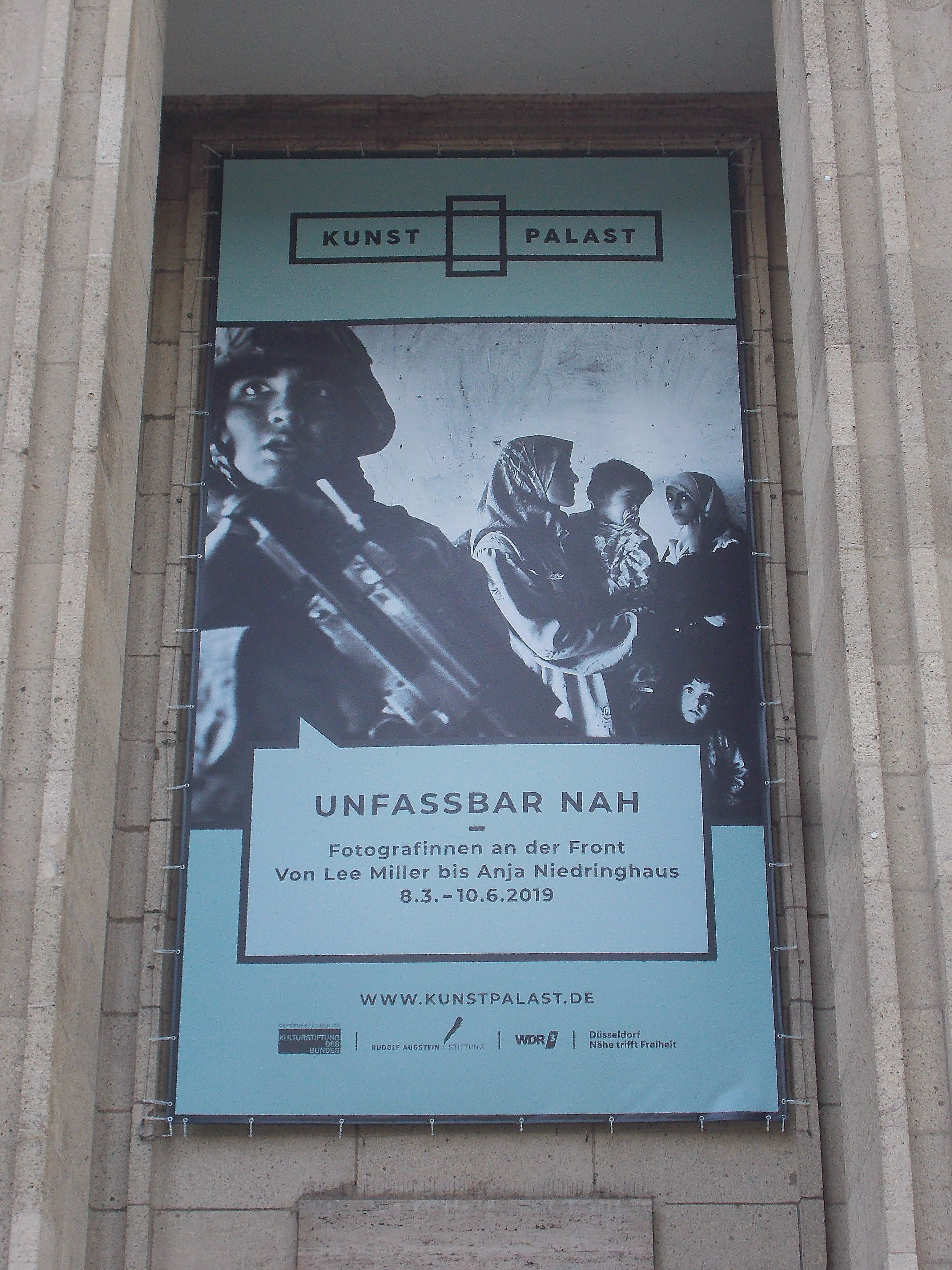 Plakat zur Ausstellung "Fotografinnen an der Front - Von Lee Miller bis Anja Niedringhaus" im Kunstpalast Düsseldorf mit Ausschnitt eines Fotos von Anja Niedringhaus.