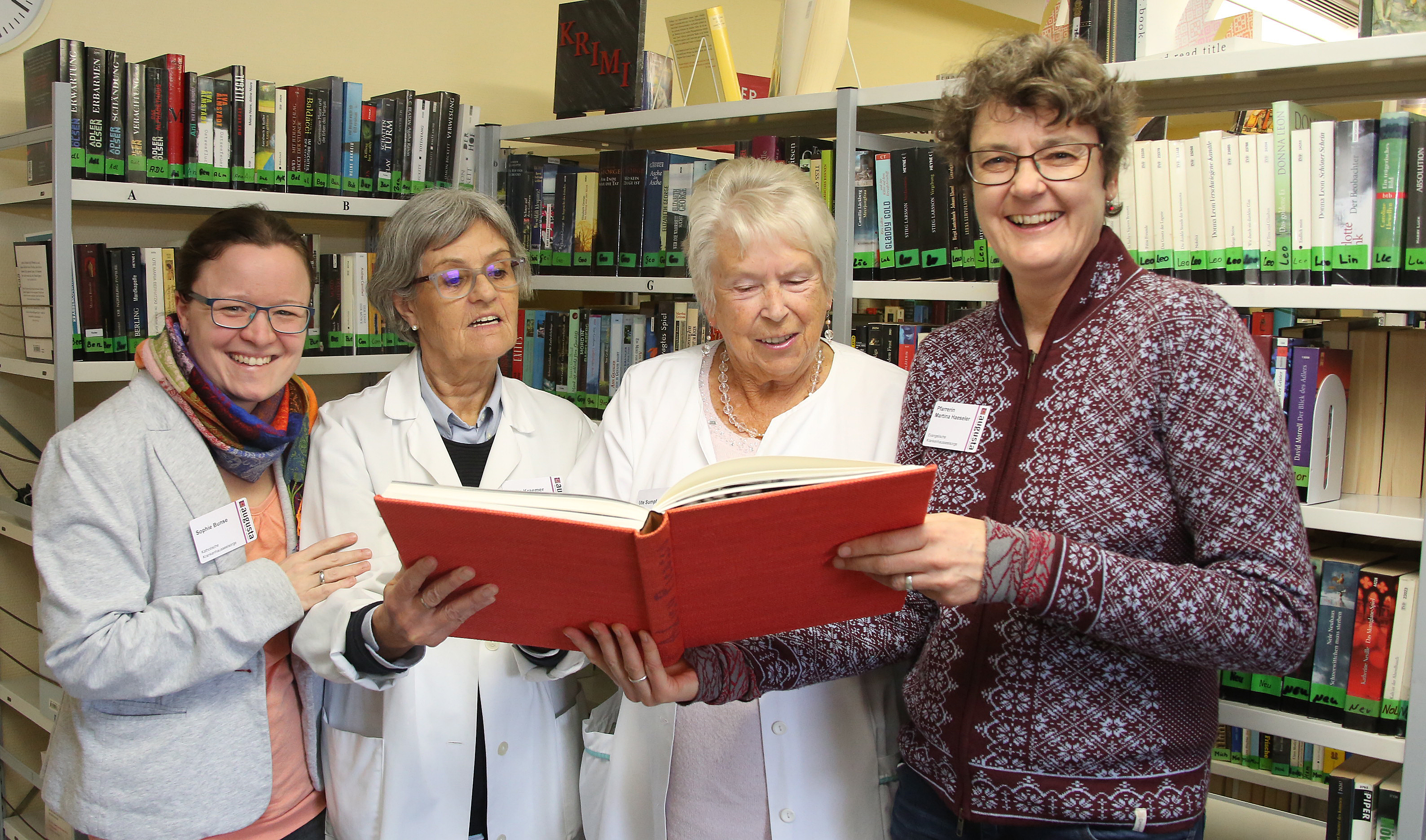 Foto (v.li.): Gemeindereferentin Sophie Bunse, die Ehrenamtlichen Marita Kraemer und Ute Sumpf sowie Pfarrerin Martina Haeseler in der Patientenbücherei.