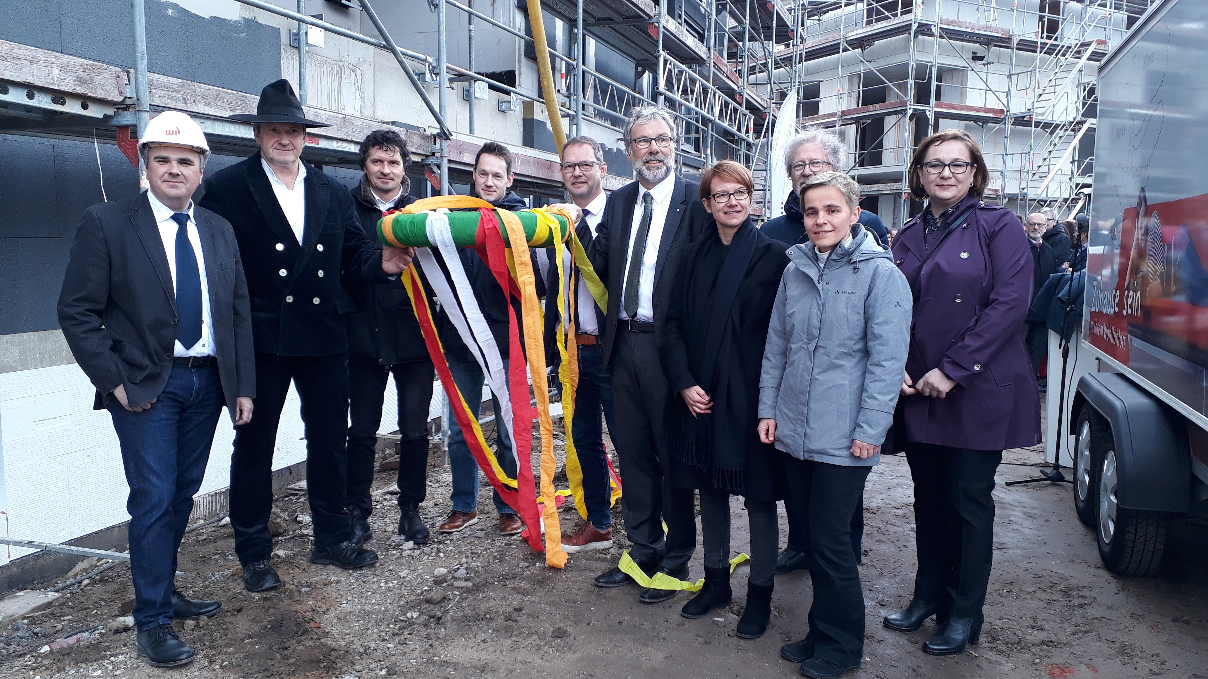 Stolz präsentieren unter anderem der Bauleiter, Architekt Stefan Husmann, Bürgermeister Dirk Buschmann, Wilhelm Krechter (Geschäftsführer Wohnbau), Pfarrerin Hanna Maas, Landschaftsarchitekt Friedhelm Schwarz, Pfarrerin Ortrun Hildebrand und Elma Bjelic (Leiterin der Tagespflege) die fertig gestellten Rohbauten. Foto: Laura Otten