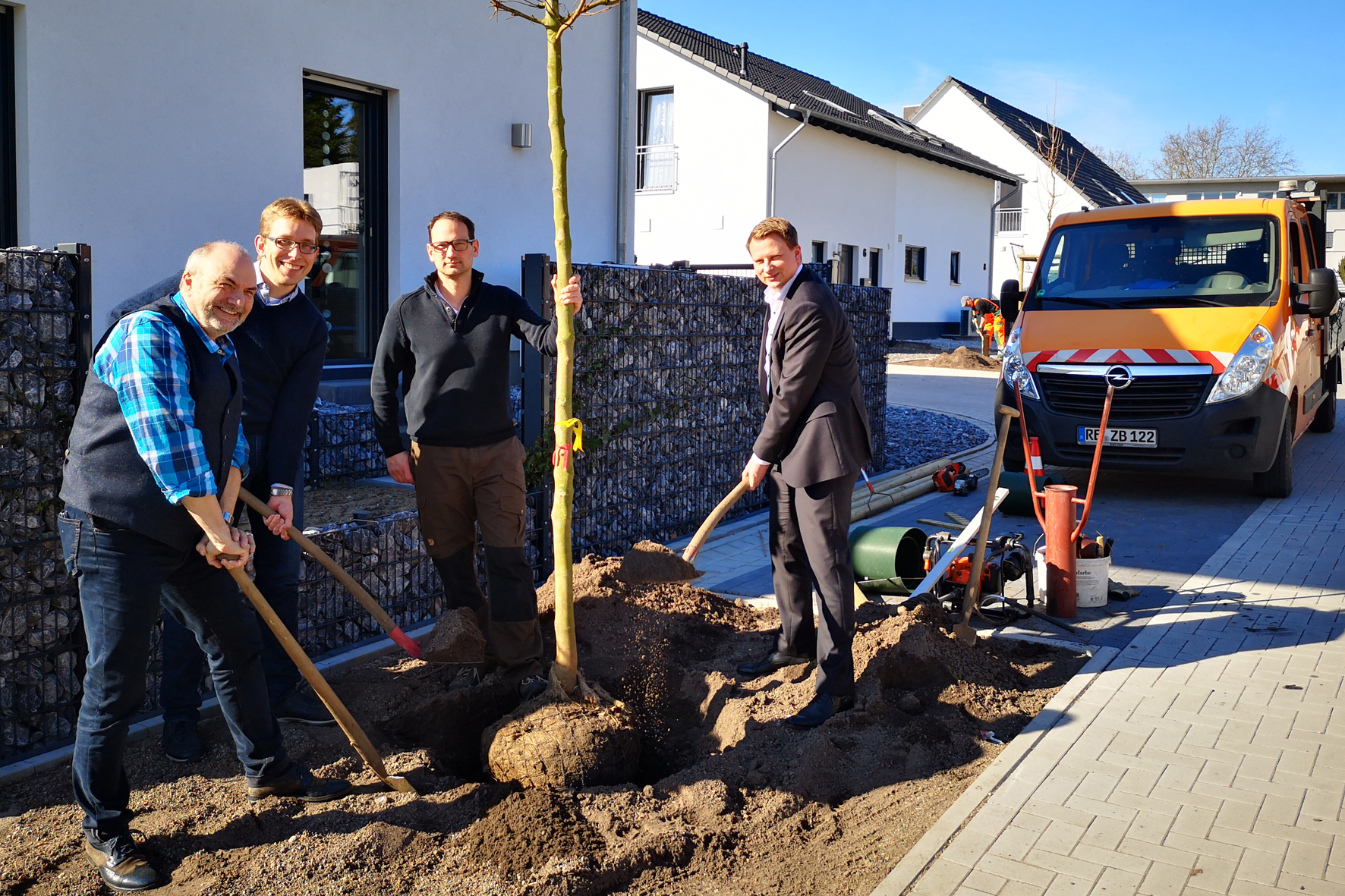 Stadtbaurat Christoph Heidenreich hilft beim Pflanzen eines Feldahorns im Mühlenhof.
