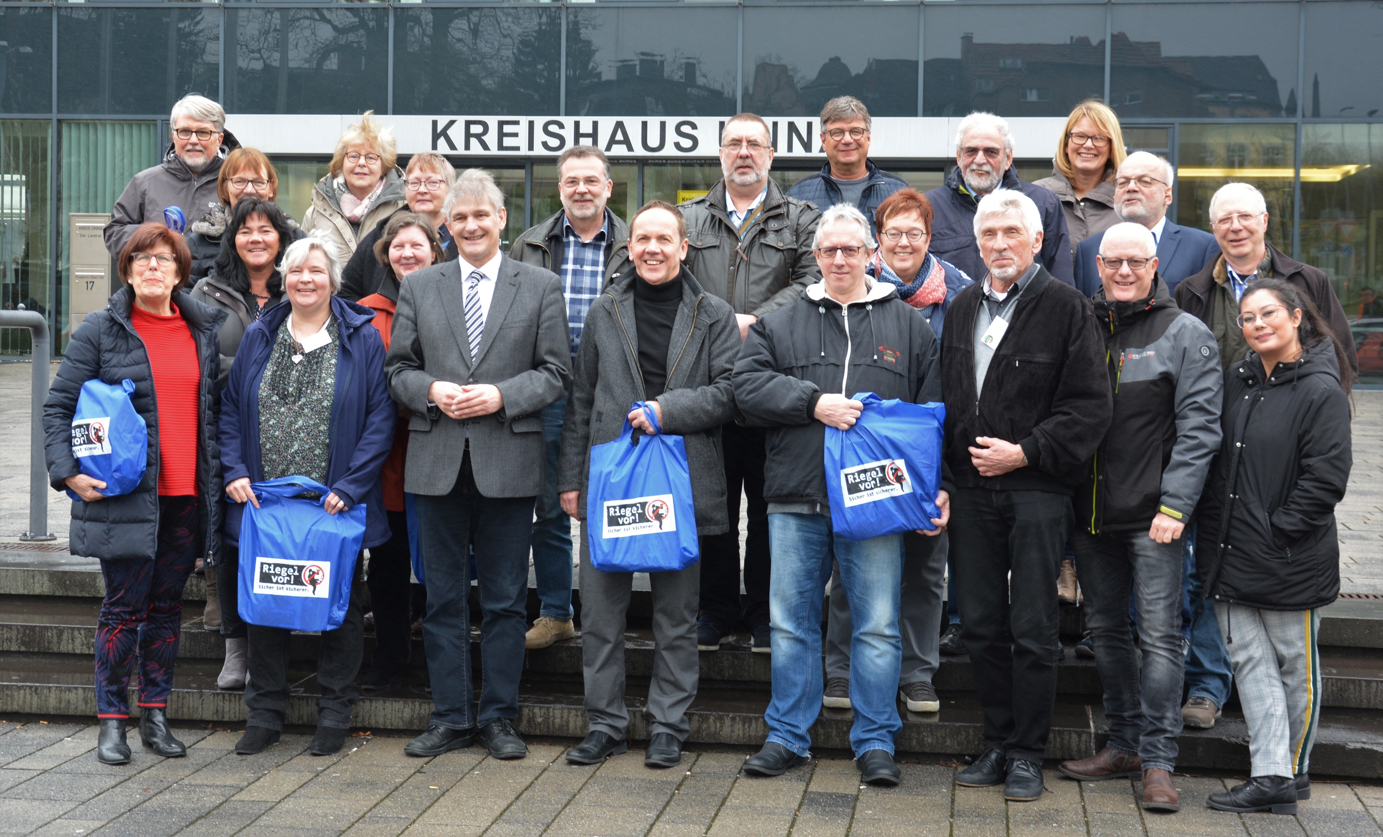 16 neue Seniorenberaterinnen und Seniorenberater beendeten am Freitag erfolgreich das einwöchige ShS-Seminar. Mit ihnen freut sich Landrat Michael Makiolla (9. von links) sowie das Tainerduo Kriminalhauptkommissarin Petra Landwehr (4. von links), Kriminalhauptkommissar Volker Timmerhoff (4. von rechts) und Kommissariatsleiterin Heike Redlin (oben rechts).