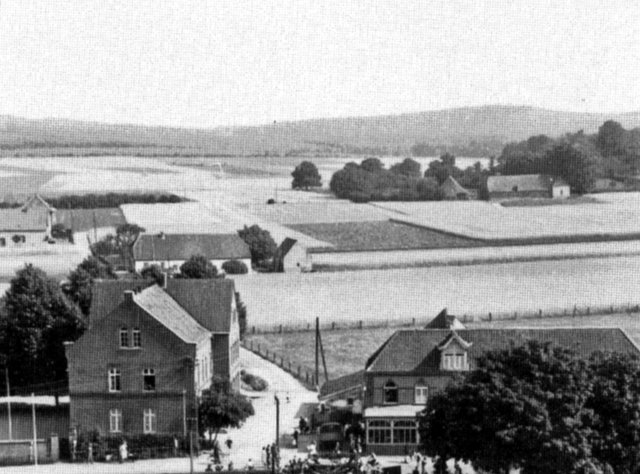 Foto von der Kirche mit Schule und Gaststätte Vink. Dahinter Bernshof und ganz hinten Weißer Rabehof. Eine historische Aufnahme (1930) aus dem Buch "Nütterden - Geschichte(n) und Bilder eines Dorfes am Niederrhein" von Otto Friedrichs 