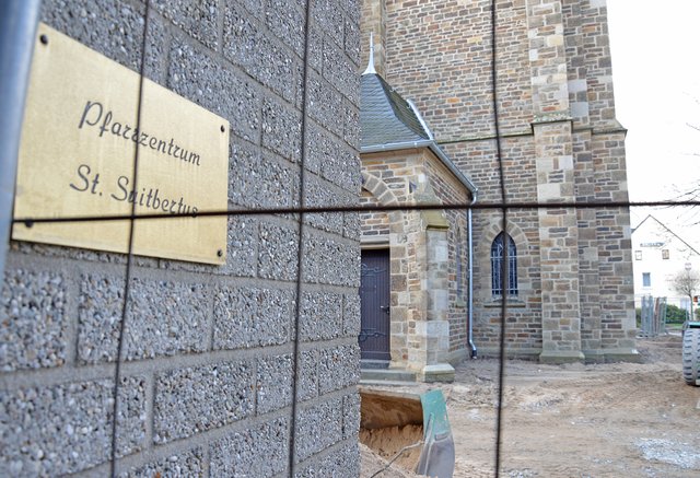 Rund um den Kirchplatz von St. Suitbertus steht ein Bauzaun, dahinter sind die Sanierungsarbeiten im vollen Gange. Gemeindemitglieder und Bürger kommen dennoch weiterhin zum westlichen Seiteneingang der Kirche, zum Pastoralbüro und zum Pfarrheim. | Foto: Maren Menke