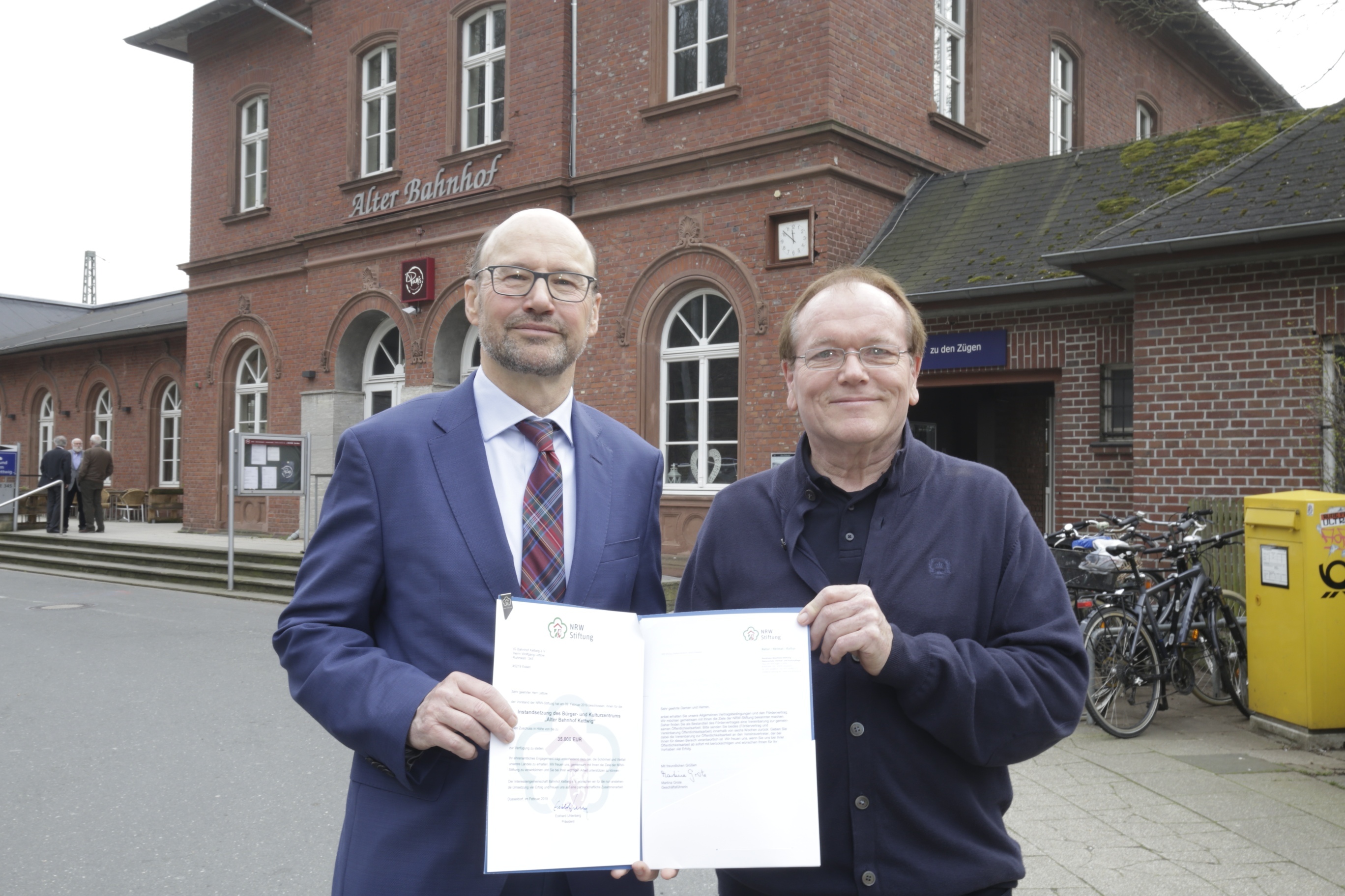 Dieser Gast kam nicht mit leeren Händen: Der frühere NRW-Europaminister und Staatskanzleichef Franz-Josef Lersch-Mense (l.) überbrachte bei einem Besuch die schriftliche Förderzusage der Nordrhein-Westfalen-Stiftung über 35.000 Euro für die Interessengemeinschaft Alter Bahnhof Kettwig, die Vereinsvorsitzender Wolfgang Lettow freudig entgengenahm.