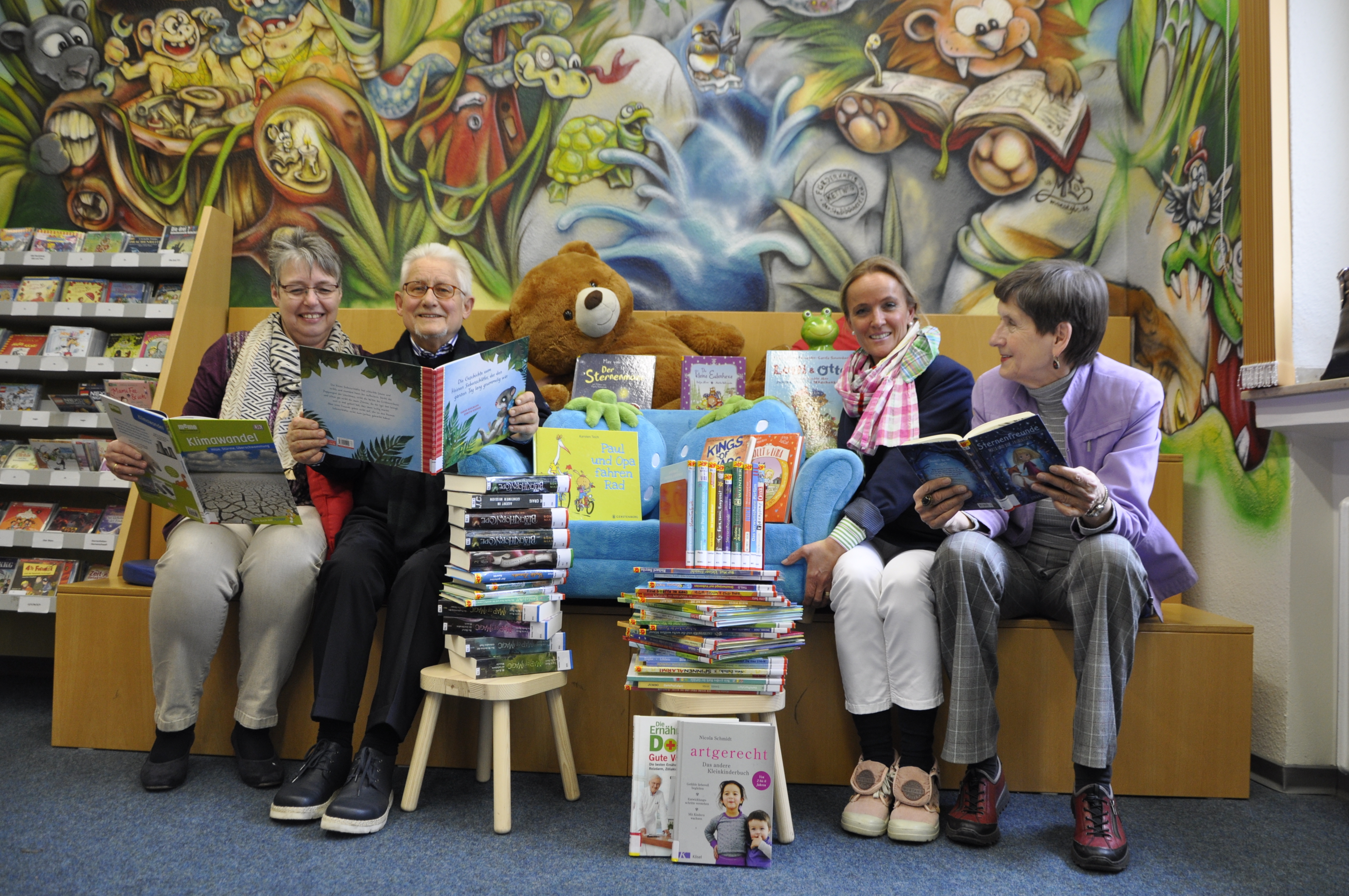 Petra Bandura und Carla Sondermann (1. und 3. v.l.) von der Stadtteilbibliothek blättern genauso begeistert in den druckfrischen Neuzugängen wie die Förderkreis-Delegation Birgit Dransfeld und Dierk Lamm.