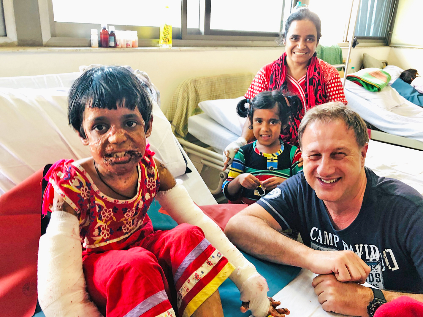 Dr. Karl Schuhmann, Chefarzt der Klinik für Plastische/Ästhetische Chirurgie und Handchirurgie am Ev. Krankenhaus Hattingen, im Kreise von Patienten im indischen Bangalore, wo er für Interplast Germany humanitäre Hilfe leistete - und seinen Urlaub dafür opferte. Foto: privat