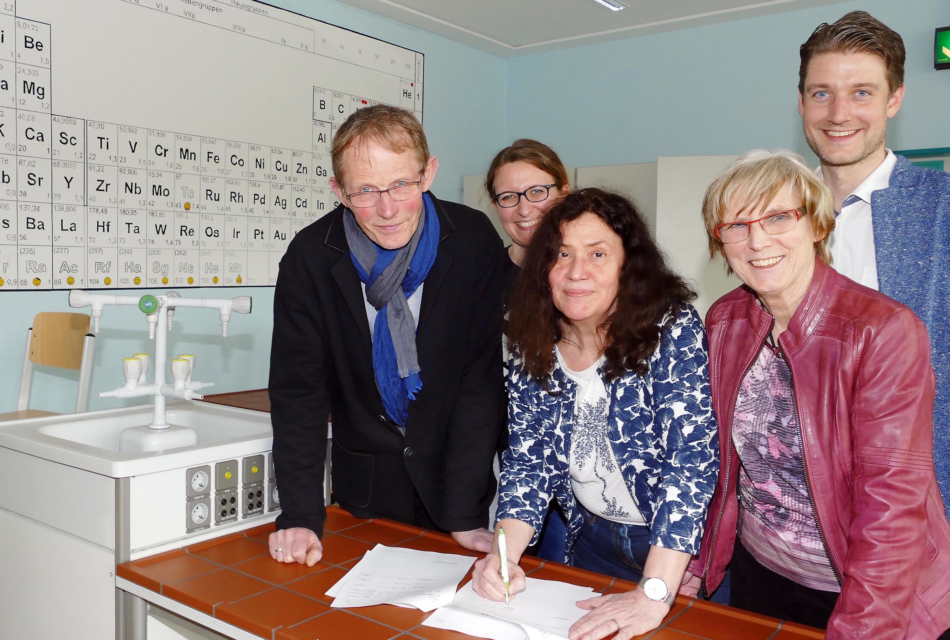 Ausbildungsleiter Karl Heinz Grafenschäfer (l.) und Schulleiterin Inge Levin (m.) präsentieren im Beisein von Matthias Labs (Koordinator berufliche Orientierung), Jasmin Grzyb-Budens (Fachbereich Chemie, 2.v.l.) und Chemielehrerin Agnes Heisig den Kooperationsvertrag.