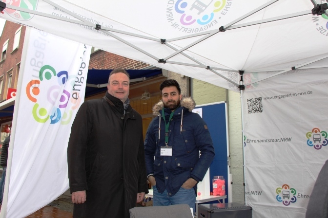 Matin Adel hatte in der Rekumer Straße einen Stand aufgebaut, um mit Bürgermeister Bodo Klimpel und weiteren interessierten Bürgerinnen und Bürgern ins Gespräch zu kommen. Foto: Stadt