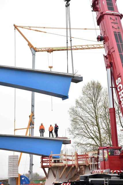 Drei Bauarbeiter schauen zu, wie sich der Brückenkopf senkt. | Foto: Ralf Beyer