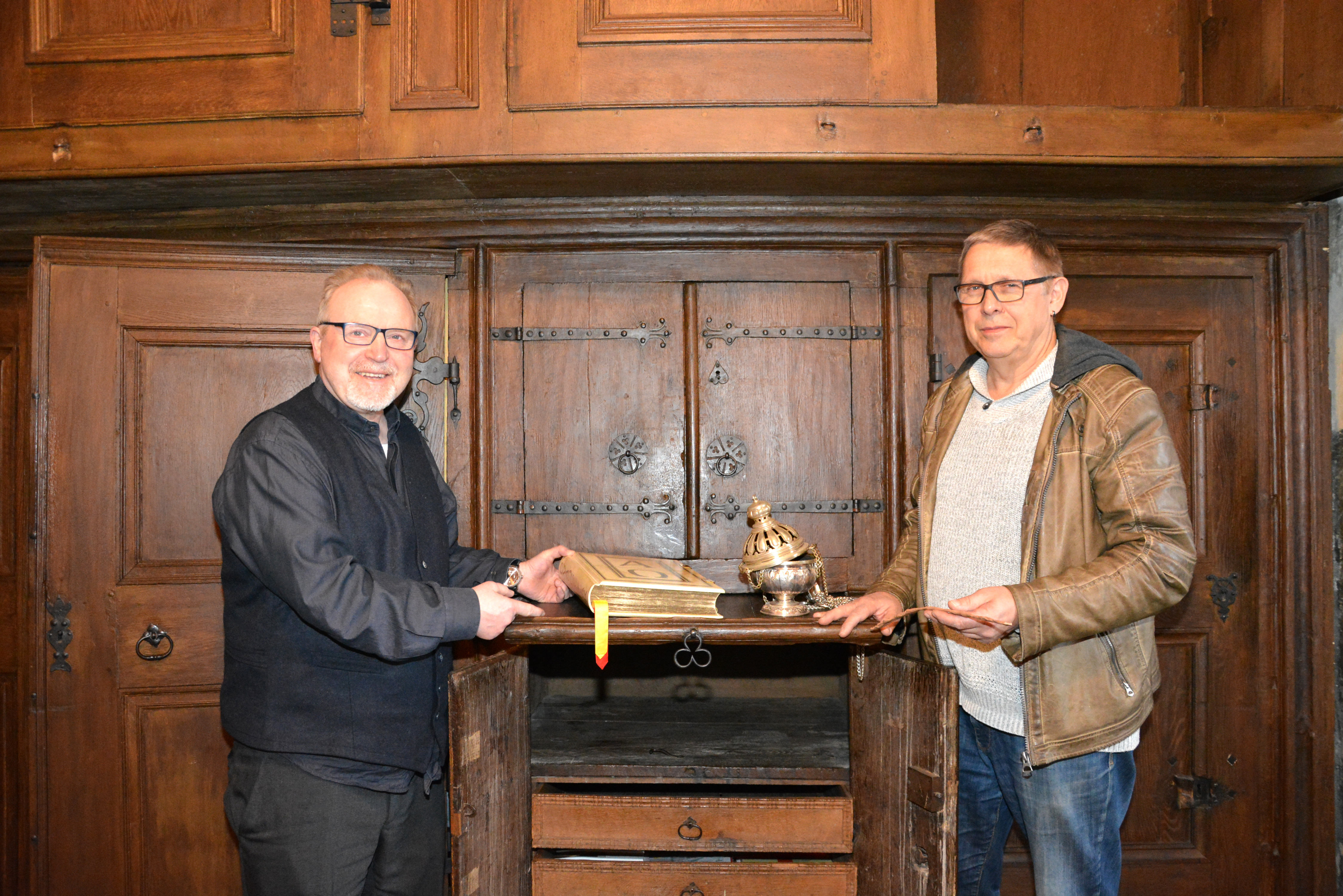 Propst Hubertus Böttcher und LWL-Bauforscher Peter Barthold vor dem ältesten dauerhaft genutzten Sakristeischrank in Westfalen: Er steht im Kloster Wedinghausen in Arnsberg.