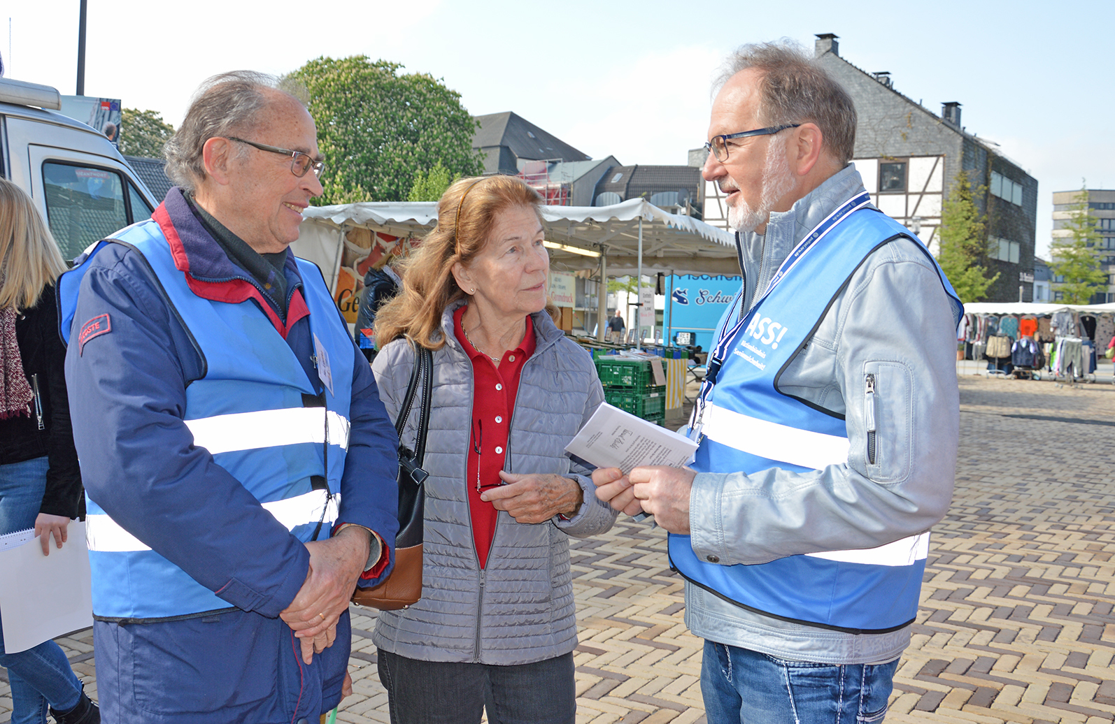 Siegberg Lüdtke (links) und Helmuth Spathmann setzten sich im Rahmen des "Aktionsbündnis Seniorensicherheit" in Velbert ehrenamtlich ein und klären Bürger, wie diese Marktbesucherin, über die Maschen der Trickbetrüger auf.