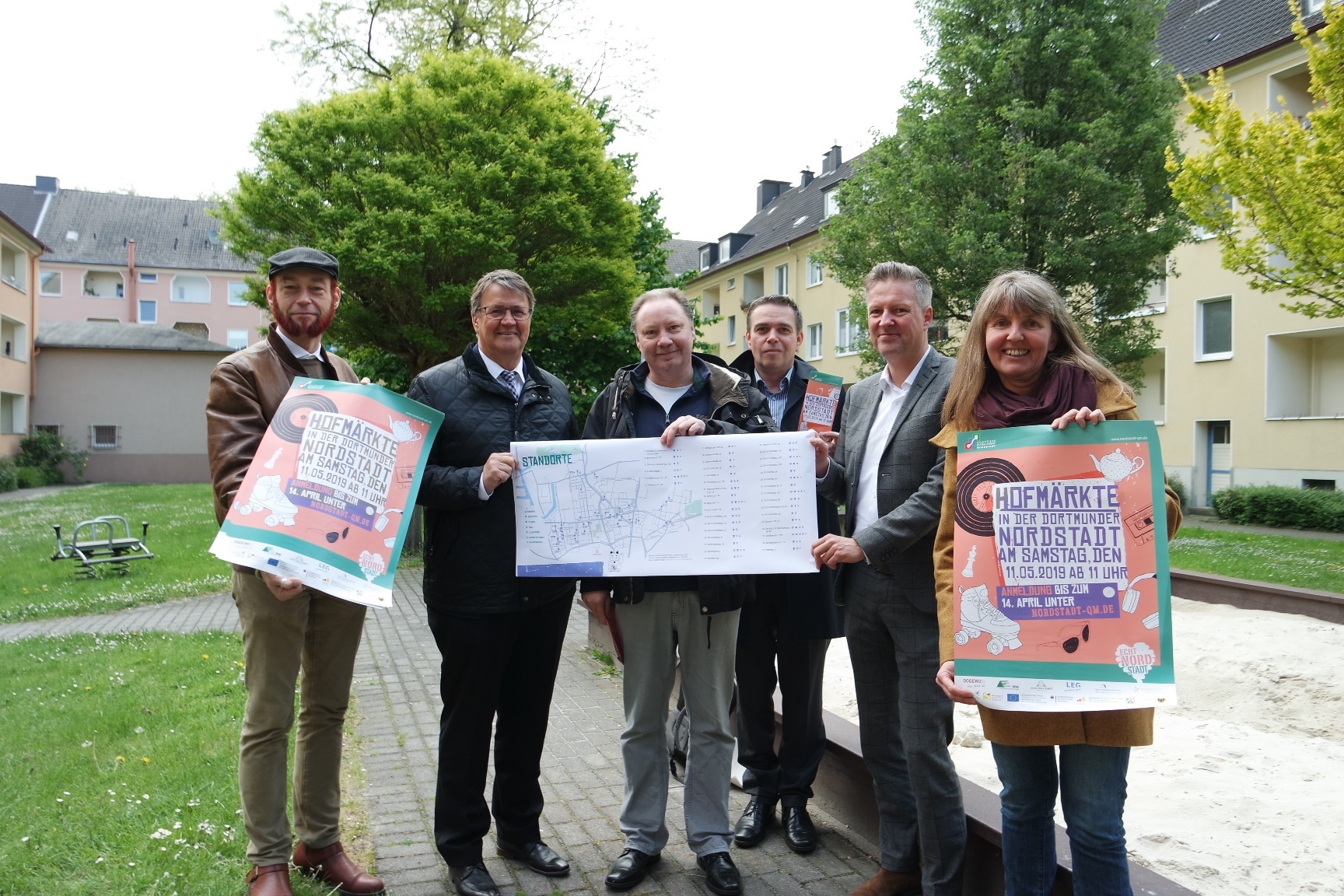 Quartiersmanager Didi Stahlschmidt, Uwe Goemann von der Stiftung Vivawest, Sozialarbeiter Alteruthemeyer und Björn Malcharczyk sowie Ulrich Benholz vom Spar- und Bauverein und Uta Wittig-Flick vom Amt für Stadterneuerung freuen sich auf viele Besucher bei den Hofmärkten, nicht nur hier an der unverhaustraße.