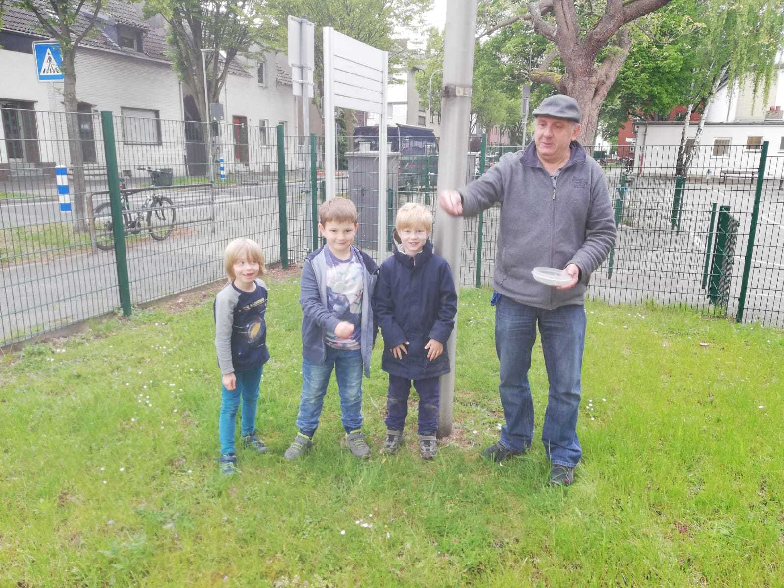 Die kleinen, umweltbewussten Drittklässler bei ihrer guten Tat mit Hausmeister Breiter.