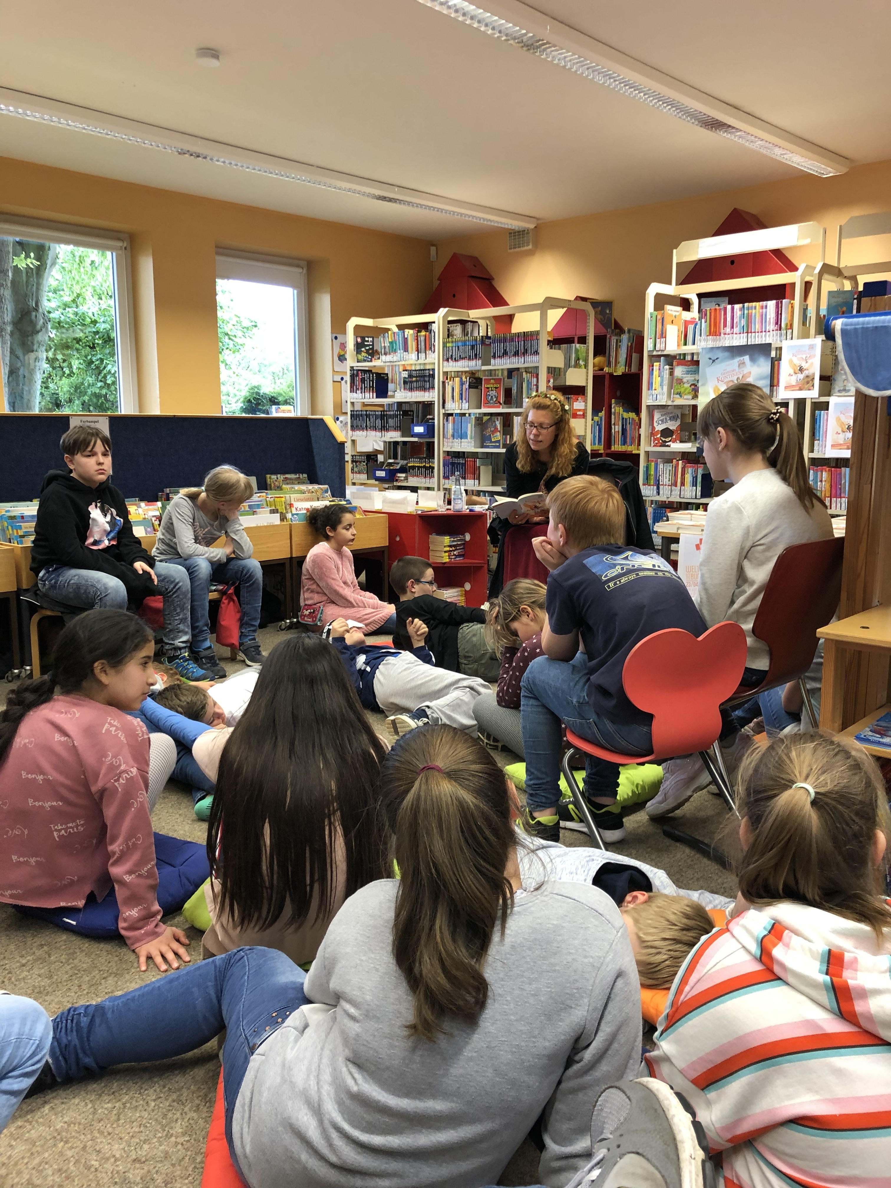 MCG-Deutschlehrerin Heike Harlinghausen liest den Fünftklässlern in der Gemeindebücherei Bönen vor.