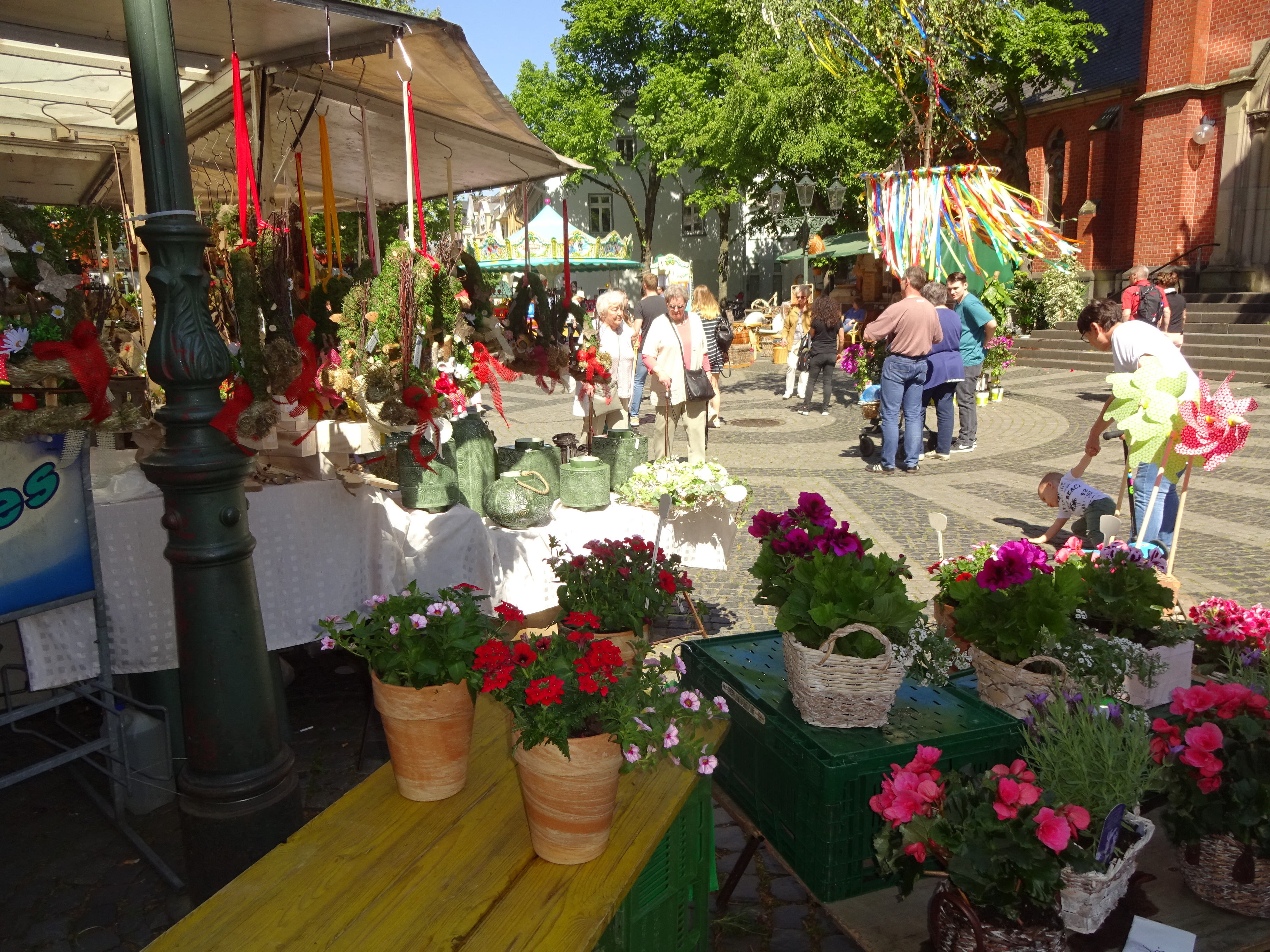 Der Maibaum vor der Kirche, vorsommerliche Angebote: Der Maimarkt in der Benrather City ist immer sehr beliebt.
^Foto: Archiv/Rhein-Bote