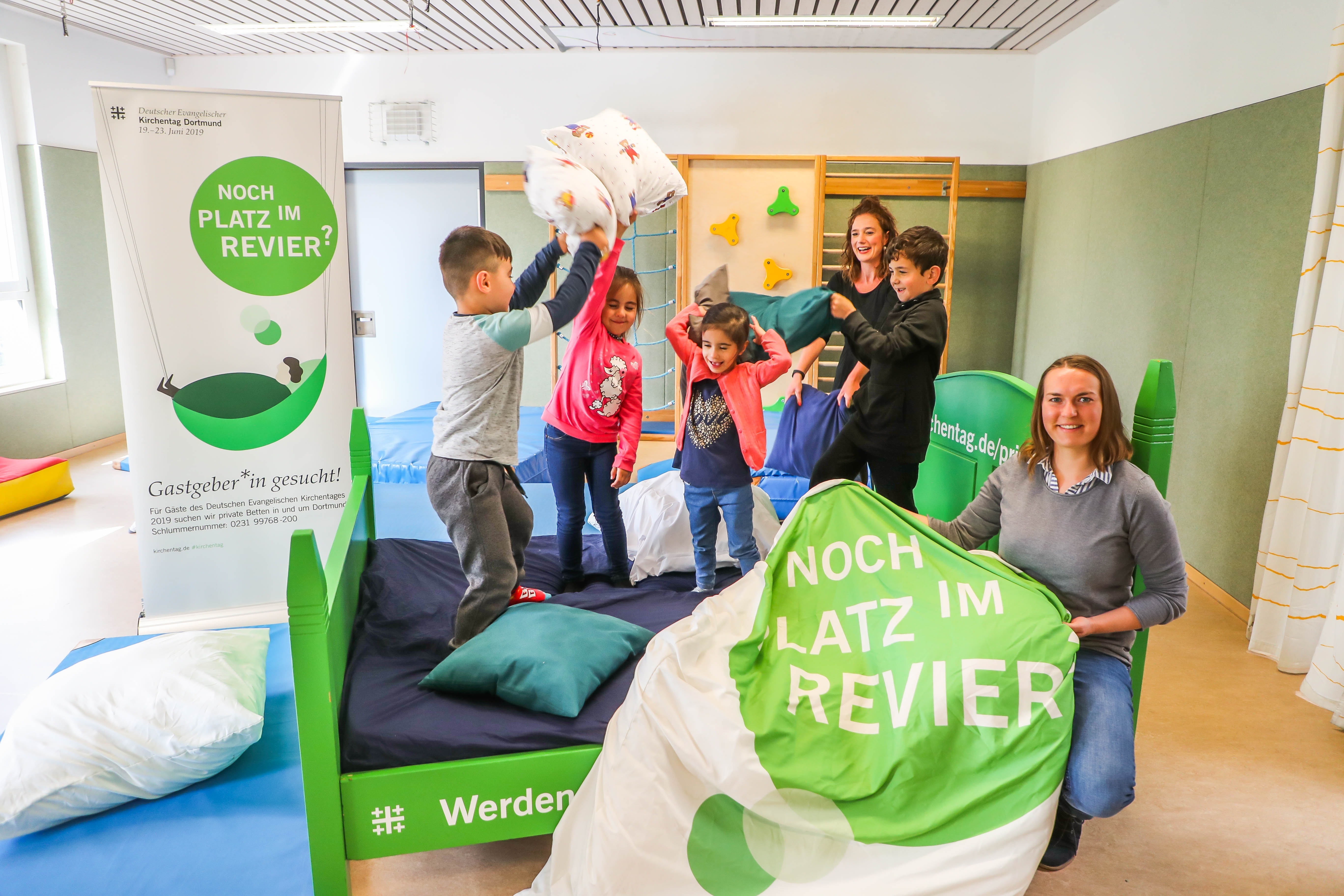 Anna-Maria Erlinghäuser (r.v.) und Laura Henter (h.) liefern sich eine Kissenschlacht mit den Kindern der FABIDO Tageseinrichtung für Kinder Uhlandstraße.