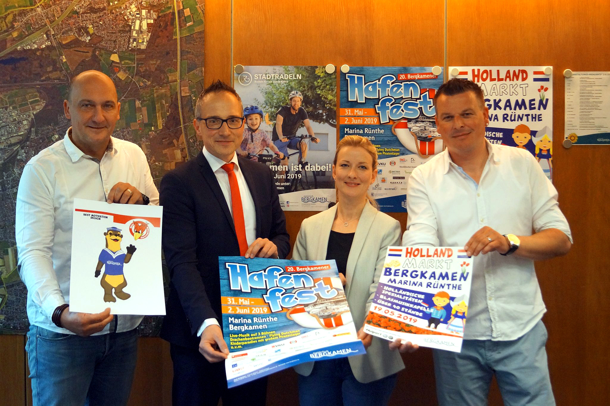 V.l.: Thomas Hartl, Leiter der zentralen Dienste, Michael Krause und Mandy Bayer für die Sparkasse Kamen-Bönen-Bergkamen als Sponsor und Karsten Quabeck vom Stadtmarketing präsentieren die Poster für die nächsten Veranstaltungen an der Marina Rünthe.