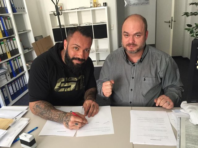 Patrick Korte setzt seine Unterschrift unter den Vertrag mit Sandro Baruth.