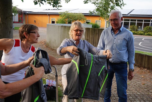 Felicitas Daum (Mitte) hat sich vorher über die Größen informiert, nun erhält jede Athletin, jeder Athlet die für sie/ihn passende Jacke.