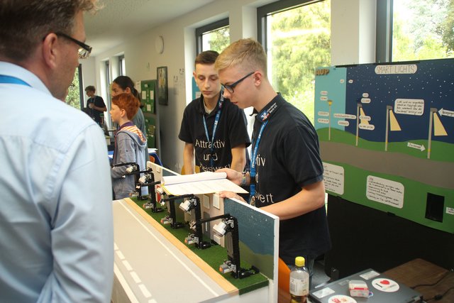 Jurymitglied Roger Dirksmeier aus Menden befragt das lokale Team „attraktivpreiswert“ vom Walburgisgymnasium zur Idee, die Lichtverschmutzung von Laternen zu verringern.