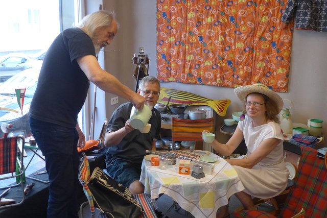 Dirk von Eicken und Bärbel Essers üben sich schon mal im Campinggefühl der Wirtschaftswunderjahre und lassen sich beim Aufbau ihrer Ausstellung vom Mit-Malocher Bernd Simmerock kräftig einschütten.