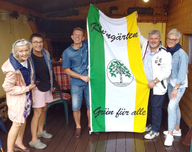 Michael Ludwig (2 v.r.) überreicht dem Vorsitzenden des Kleingartenvereins Wieliczka, Jerzyk Suchy, als Gastgeschenk die Fahne des Bezirksverband Hamm-Kreis Unna der Kleingärtner. Fotos: Stadt Bergkamen