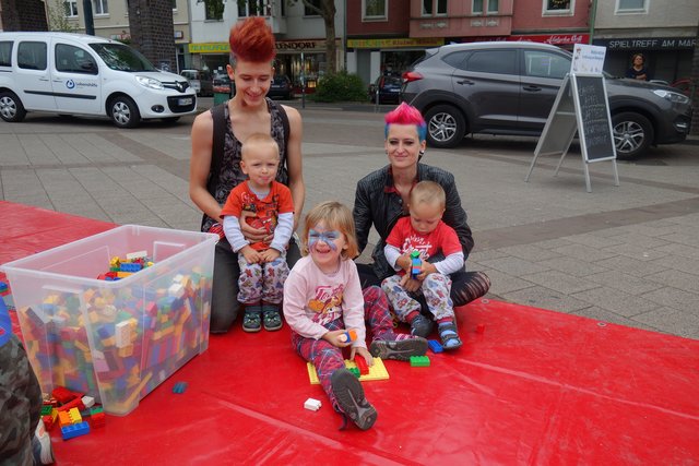 Bunt -Hier geht's lang! Eltern Jörg und Sara mit Töchterchen Ronja- sitzend; dazu gesellen sich von Freunden die Zwillinge Max li. und Ben