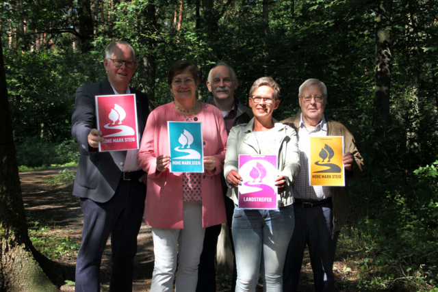 Landrat Cay Süberkrüb, RVR-Regionaldirektorin Karola Geiß-Netthöfel, Heinrich Jolk (Projektleiter RVR), Dagmar Beckmann (Geschäftsführerin Naturpark Hohe Mark) und Wilhelm Höhner (SGV; v.l.n.r.) präsentieren die Schilder, mit denen in den nächsten Wochen der Hohe Mark Steig, die Zuwegungen und die Landstreifer ausgezeichnet werden.