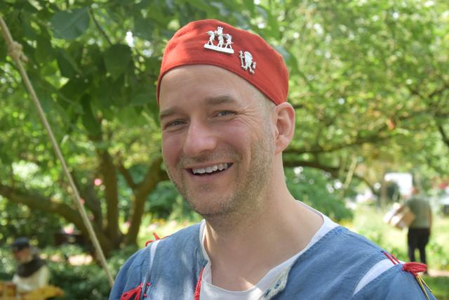 Bei den Abzeichen am Hut von Andreas Gilles handelt es sich um sogenannte Vulgärabzeichen. Die Zinnabzeichen waren so etwas wie die Buttons des Mittelalters: Die Menschen brachten sie sich als Andenken von Reisen oder von Pilgerfahrten mit. Es konnten religiöse Symbole, Buchstaben als Abkürzungen von Sinnsprüchen (z.B. A für "Amor vincit omnia"/"Liebe besiegt alles") oder Vulgärabzeichen mit derben Anspielungen sein.
Das linke Abzeichen zeigt eine "verkehrte Welt": Eine Vagina als Symbol für die Frau wird als Königin in einer Sänfte von Penissen getragen. Nach damaligem Verständnis sollte aber eigentlich die Frau Untertan sein. Das rechte Abzeichen ist die "pilgernde Vagina", ein Spottabzeichen. Sie ist mit den typischen Accessoires eines Pilgers ausgestattet: Pilgerhut, Pilgerstab, Rosenkranz und sogar Trippen.