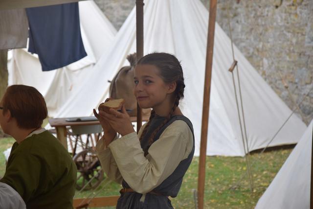 Auch gegessen wird im Lager mittelalterlich - Häufig gibt es Suppe oder Eintopf mit Brot, zum Frühstück Grießbrei mit Früchten. Sonntags wird auch mal ein Hähnchen am Spieß gegrillt. Als Zwischenmahlzeit für Berenike dient hier eine Scheibe Brot.
