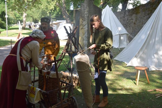 Links unten im Bild ist der Leiterwagen des Lagers. Auf seiner Ladefläche befindet sich eine Weidenkiepe, die sozusagen den Rucksack des Mittelalters darstellte.