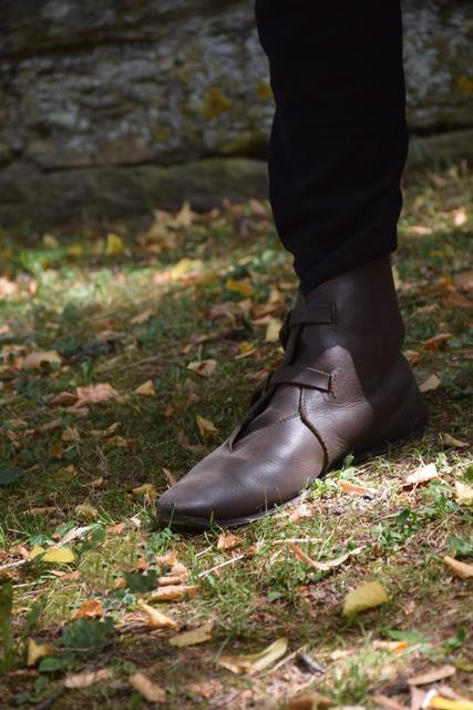 Die Lagerteilnehmer sind von Kopf bis Fuß mittelalterlich ausgestattet. Da darf auch das richtige Schuhwerk nicht fehlen: In diesem Fall Lederschuhe mit genagelter Sohle. 