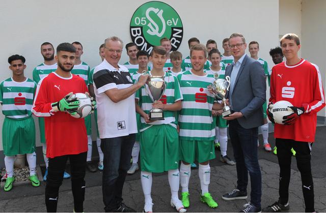 Nils Hagenkötter (2. von links), Leiter der Sparkassengeschäftsstelle in Witten-Bommern, überreicht den Fair-Play-Pokal an Maximilian Arldt, (3. von links) den Spielführer der Bommeraner A-Junioren. Klaus-Dieter Leiendecker, (vorn, 2. von rechts) Vorsitzender des Fußballkreises Bochum, lobte die faire Spielweise und gratulierte ebenfalls zum Gewinn des Fair-Play-Pokals.