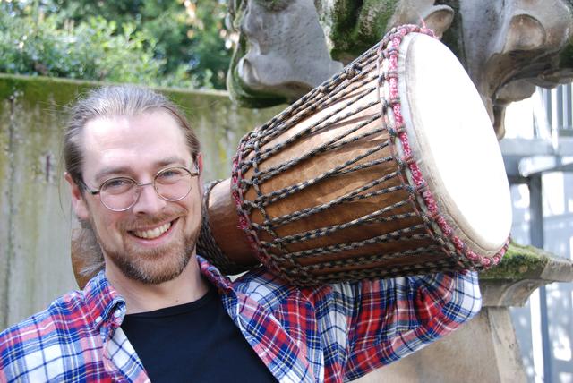 Graham Sanders stemmt die schwere "Djembe". Die Trommel ist eins der eingesetzten Musikinstrumente.