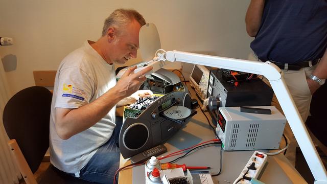 Gemeinsam mit den Besitzern werden defekte Geräte – wie hier ein Disk-Player - von ehrenamtlichen Reparateuren im Repair Cafe Nette unter die Lupe genommen und nach Möglichkeit wieder repariert.