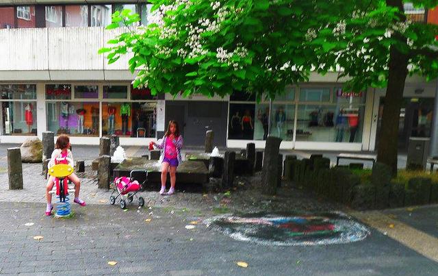Blick zurück in vergangene Zeiten: Spielende Kinder am Brunnen und unter dem Trompetenbaum auf dem ehemaligen Kolpingplatz.