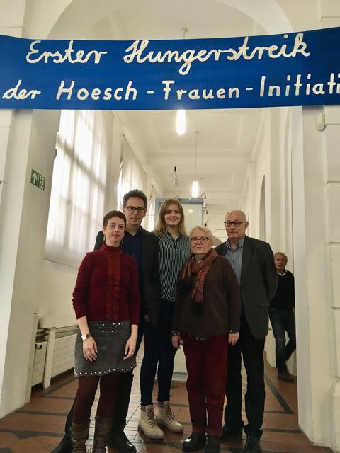 Unter einem Banner zum Hungerstreik der Hoesch-Fraueninitiative (v.li.): Isolde Parussel (Leiterin des Hoesch-Museums), Dr. Jens Stöcker (Direktor des Museums für Kunst und Kulturgeschichte), Mit-Kuratorin Svenja Grawe (Ruhr-Universität Bochum), Zeitzeugin Rita Schenkmann-Raguse und Dr. Karl Lauschke, Vorsitzender der Freunde des Hoesch-Museums.