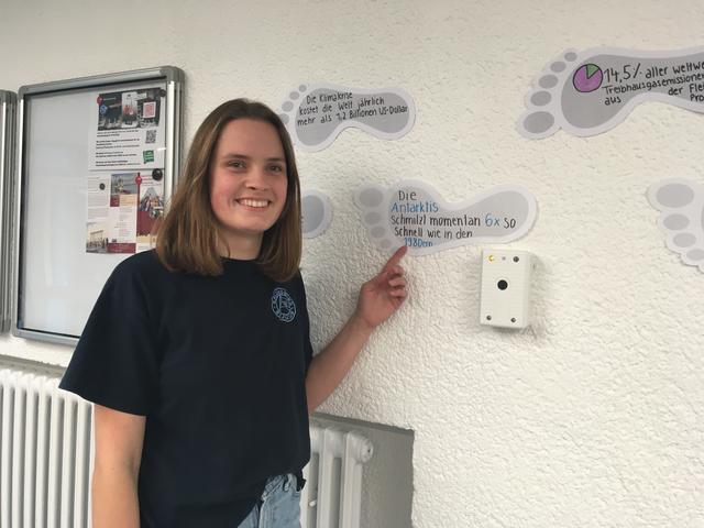 Birte zeigt die "Fußabdrücke für mehr Klimaschutz", die sich in der ganzen Schule finden.