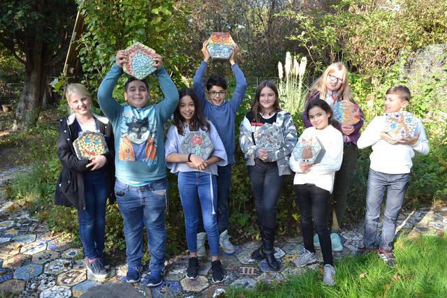 Die Macher und ihr Werk: Charlene Czika, Melina Niemann, Ceylin Gök, Hasan Özdoganci, Lea Eze, Romaisa Faiz, Amir Al Musafar, Gleb Hasenkampf präsentieren stolz ihre Mosaike für den Schulgarten..