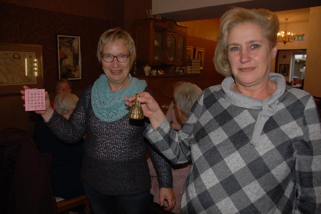 Die Koordinatorinnen des Bingo-Nachmittags im Amaliencafé, Christina Görsch (li.) und Anja Schlothane mit Spielkarte und Zeremonieglöckchen.