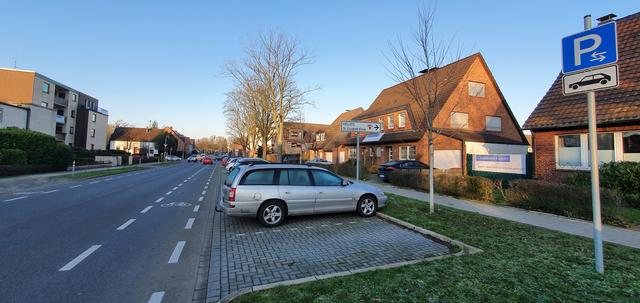 Auf beiden Seiten der Straße hängen die Plakate an Häusern und Zäunen.