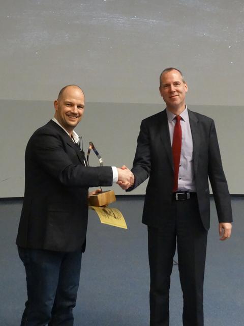 Tobias Ortmann (li./ Regionalkoordinator Mathematikwettbewerb Dortmund) übergibt den Siegerpokal an Jens Schwegmann (stellv. Schulleiter IKG)