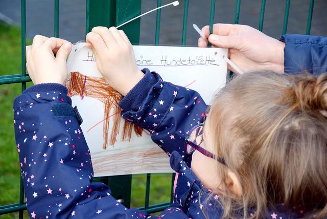 Die Kinder haben ihre Schilder bereits am Zaun des Kindergartens befestigt.