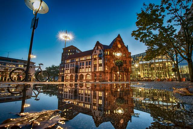 Die Stadt lässt die Lichter am Friedensplatz erlöschen - hier ein Blick auf das alte Stadthaus, das sich in einer Pfütze spiegel.