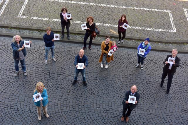 Das Redaktionsteam präsentiert das Jubiläumsbuch gemeinsam mit Oberbürgermeister Bernd Tischler auf dem Rathausplatz. Foto: Jörg Schimmel