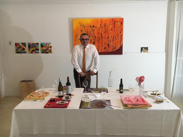 N.K.MIP während einer Ausstellung in der Galerie an der Ruhr vor seiner Malerei - auf dem Tisch Arbeiten aus Stoffen von Sabine Geiger-Brée