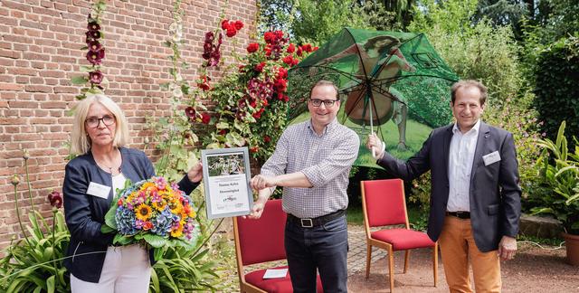 Oberbürgermeister Thomas Kufen (Bildmitte) erhält von Andrea Beckmann und Thomas Banzhaf, Mustergartenanlage im Grugapark e.V., die Ehrenmitgliedsurkunde.