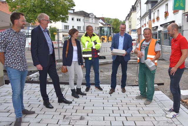 Dieser Granit, hier von Martin Kramme und Polier Alic Semsudin (2. und 3. v.r.) Nils Hering (Bauleiter), Günter Freck (Beigeordneter), Susanne Weihrauch (Architekturbüro), Mateusz Lesniak, (zuständiger Bauleiter der Verwaltung) und Sebastian Mennigmann (Baufirma) vorgestellt, wird bei der Umgestaltung der Fröndenberger Innenstadt verwendet.