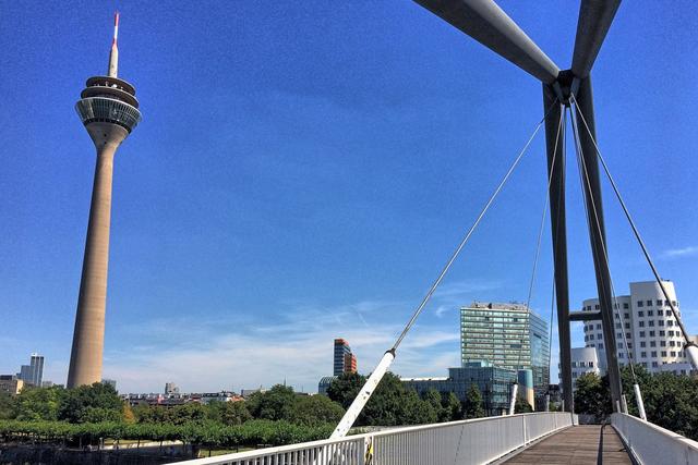 Auf dem Weg zum Paradiesstrand: Die Fußgängerbrücke mit Rheinturm und Gehry-Bauten